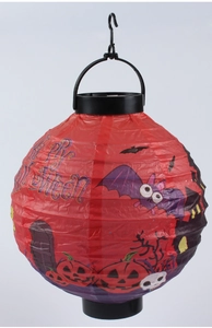 Detail of red Halloween paper lantern with pumpkin and skeleton prints and hanging hook