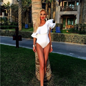 Dettaglio del costume da bagno bianco a una spalla con volant indossato in un resort estivo