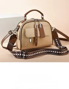 Detail of minimalist beige and brown faux leather tote with wide patterned shoulder strap