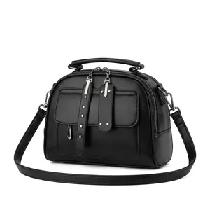 Detail shot of black leather tote bag with metallic stud pockets and detachable shoulder strap