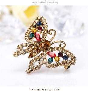 Close-up of vintage golden butterfly brooch with colorful rhinestones and crystal details
