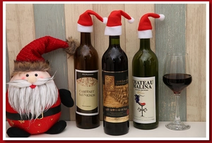 Mini red Christmas hats decorating wine bottles and glasses in a festive holiday setting
