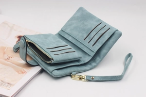 Detail of light blue matte wallet featuring card slots, zipper coin pocket and wrist strap
