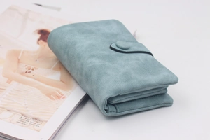 Macro detail of a light blue matte trifold wallet with multiple interior card slots
