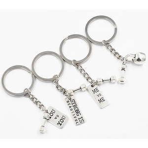 Detail of silver metal barbell keychains with motivational engraved plaques on white background