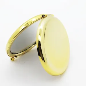 Portable round folding makeup mirror in polished gold metal with a double-sided design