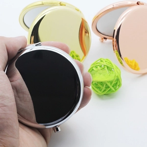 Close-up of portable round metal mirrors in silver, gold, and rose gold plating