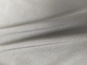 Dettaglio della trama del tessuto nero con cuciture rifinite per costume da bagno aderente