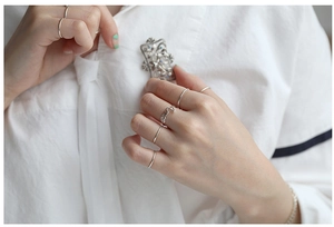 Minimalist S925 sterling silver thin rings set worn with a vintage flower brooch