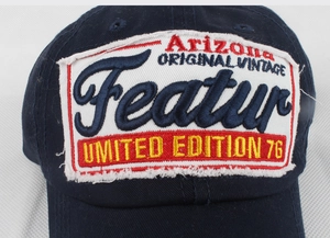 Close-up of vintage navy baseball cap with Arizona Featur embroidered patch and frayed edges
