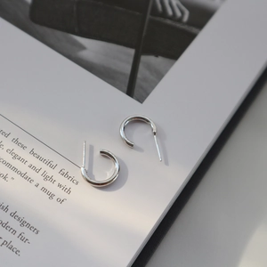 Minimalist S925 sterling silver geometric C-shaped earrings on a stylish magazine