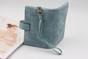 Detail view of a matte teal PU leather trifold wallet with gold hook and wrist strap