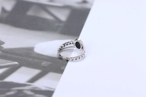 Detailed view of S925 sterling silver ring with black agate and woven chain band texture
