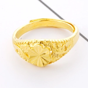 Adjustable gold flower ring with intricate octagonal sun pattern engraving on a white surface