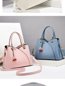 Detail view of pink and blue leather handbags with cherry charms and matte finish texture