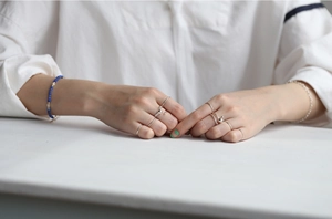 Minimalist S925 sterling silver thin band rings and beaded bracelet on model hand
