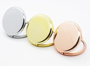Three circular folding compact mirrors in silver, gold, and rose gold finish on white background