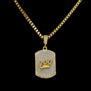 Close-up of gold hip hop dog tag necklace with crystal 100 emoji and glittery finish