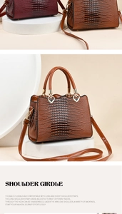 Détail d'un sac à main brillant embossé crocodile avec breloque coeur et anses rondes