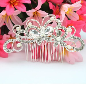 Close-up of bridal silver metal hair comb with white pearls and clear rhinestones
