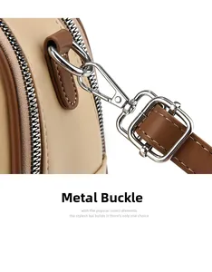 Close-up of adjustable silver-tone buckle and detachable clasp on beige leather tote