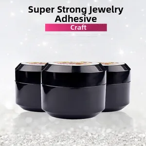 Three jars of strong nail art glue for metal charms and rhinestones on silver background