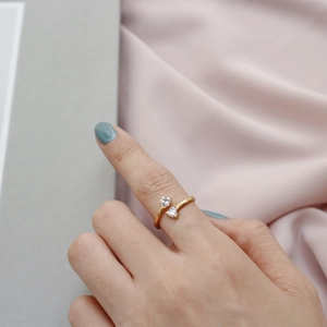 Detailed view of an open gold-plated silver ring featuring two heart-shaped zircons
