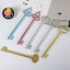 Set of retro key-shaped pens in gold, silver, pink and blue on a minimalist desk