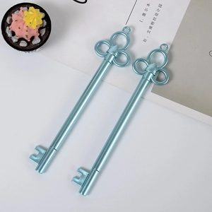 Close-up of two light blue key-shaped gel pens with metallic finish on a white desk