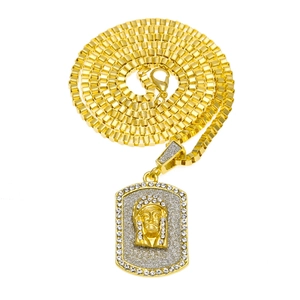 Detailed view of gold dog tag pendant with 3D face relief and sparkly rhinestones