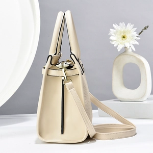 Detail of creamy white leather handbag featuring crocodile pattern and gold hardware