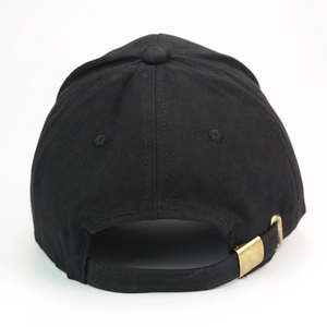 Detail of adjustable brass metal buckle and thick cotton fabric on black baseball cap