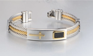 Macro view of two-tone cable cross bracelet with gold and silver stainless steel details