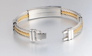 Macro shot of two-tone gold and silver steel cable bracelet with brushed metal clasp