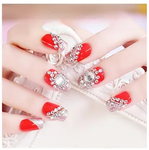 Detailed view of luxury red press-on nails with silver glitter and rhinestone accents