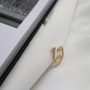 Detail of adjustable gold ring featuring two heart-shaped cubic zirconia stones