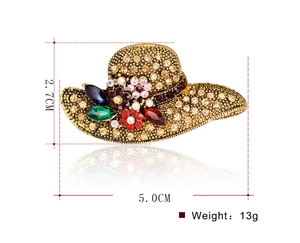 Detailed view of vintage gold hat brooch with colored rhinestones and size measurements
