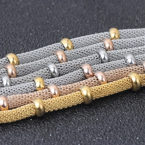 Macro detail of 4mm stainless steel mesh chain bracelets with polished gold beads