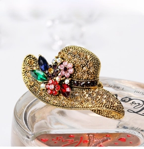 Macro detail of sun hat brooch with vintage gold finish and colorful rhinestones