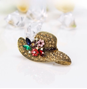 Close-up of vintage gold sun hat brooch with colorful crystals and sparkling rhinestones