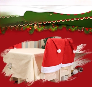 Detail of red Santa hat chair covers and beige embroidered tablecloth for Christmas decor