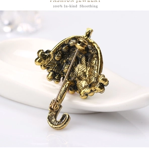 Macro detail of the metal pin back and umbrella brooch structure on white background