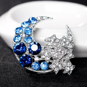 Star and crescent moon brooch featuring sparkling blue and white crystals in silver finish
