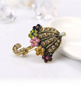 Macro detail of umbrella brooch with amber rhinestones and colorful crystal flowers