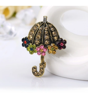 Close-up of vintage umbrella brooch with champagne crystals on elegant white swan decor