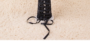 Detailed view of black lace arm warmers with corset-style lacing on soft plush rug