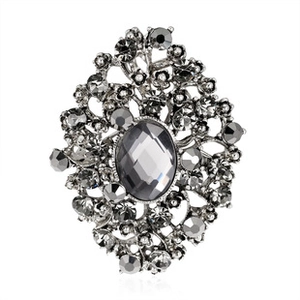 Detailed macro view of vintage silver floral brooch with grey rhinestones and oval gemstone