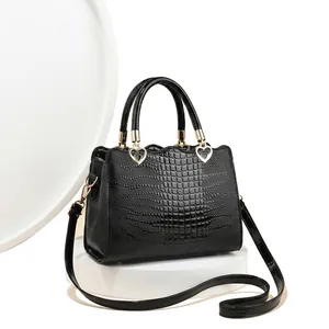 Détails du sac à main noir brillant embossé crocodile avec ornements en cœur doré