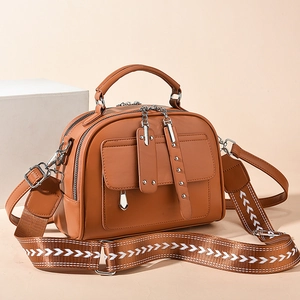 Tan leather shoulder bag with geometric patterned wide strap and double zipper closure