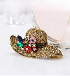 Detailed macro view of vintage sun hat brooch with colorful crystals and antique gold finish